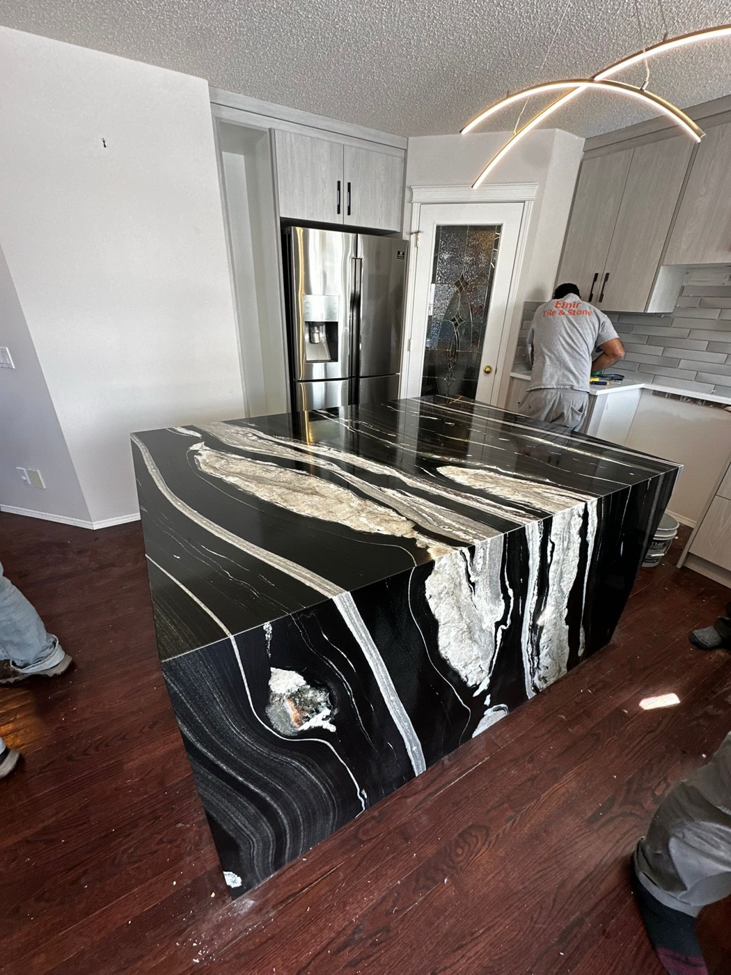 Dramatic black granite waterfall island with white veining installed in a Calgary kitchen
