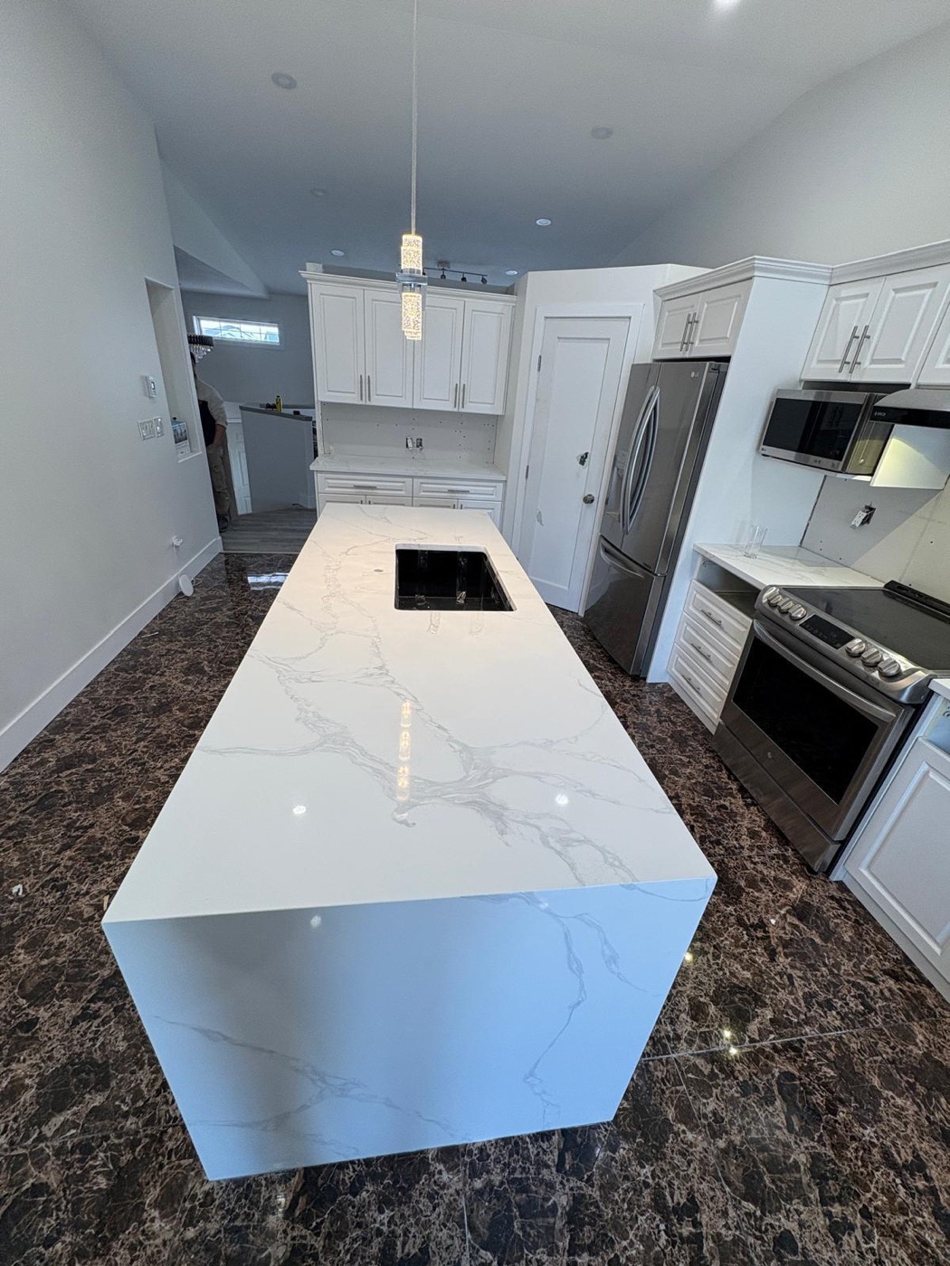 Calacatta quartz waterfall island in a modern white Calgary kitchen