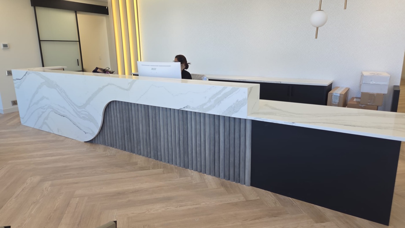 Commercial stone reception desk fabricated and installed by Bedrock Countertops in Calgary