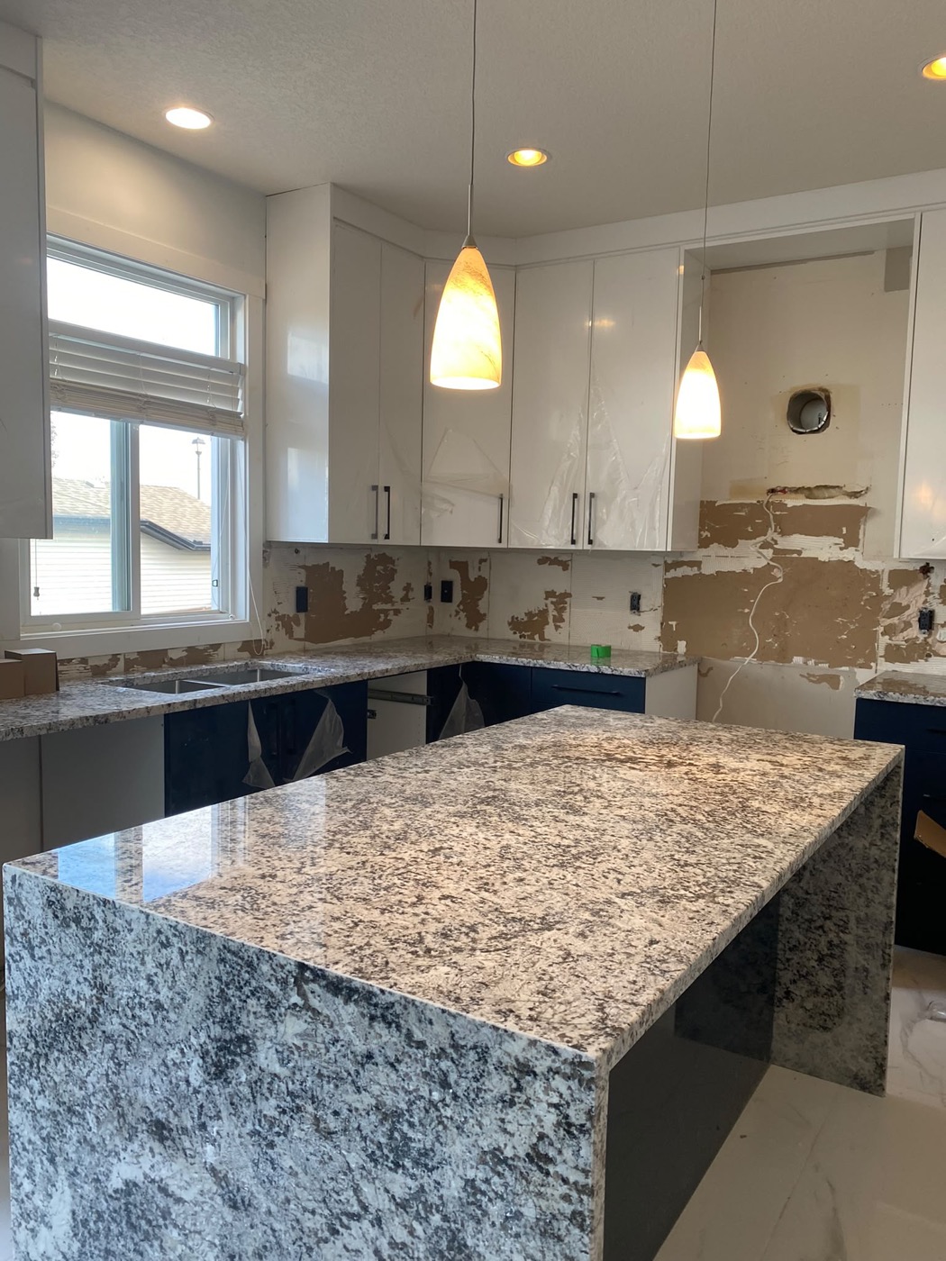 Grey granite kitchen island with waterfall edge in a new Calgary home