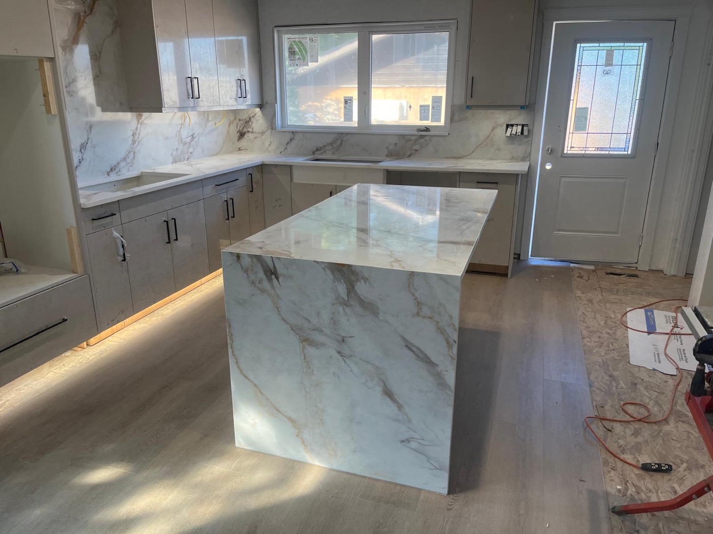 Marble-look waterfall island installed during a Calgary kitchen renovation