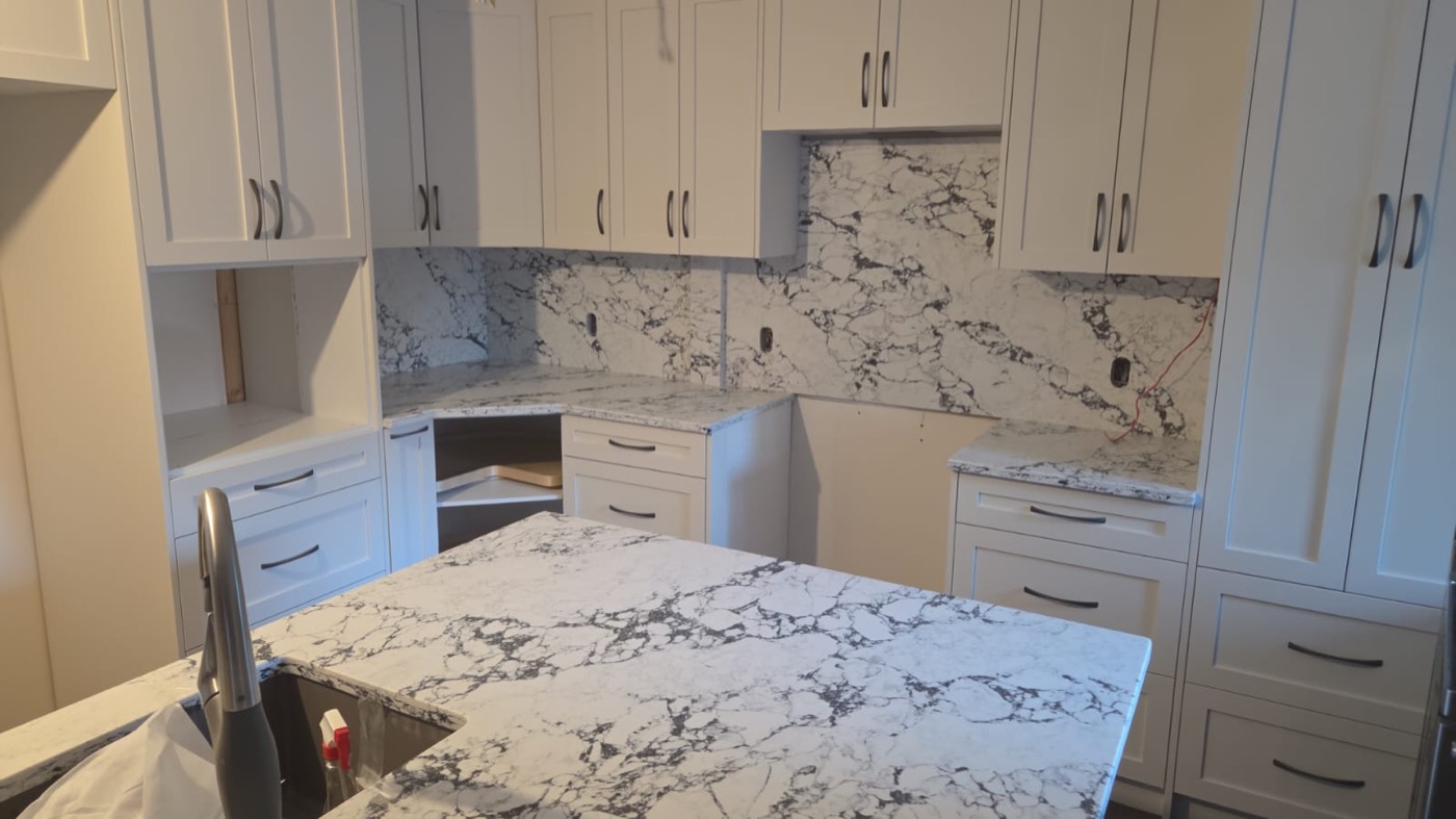 White quartz countertops with matching full-height stone backsplash in Calgary